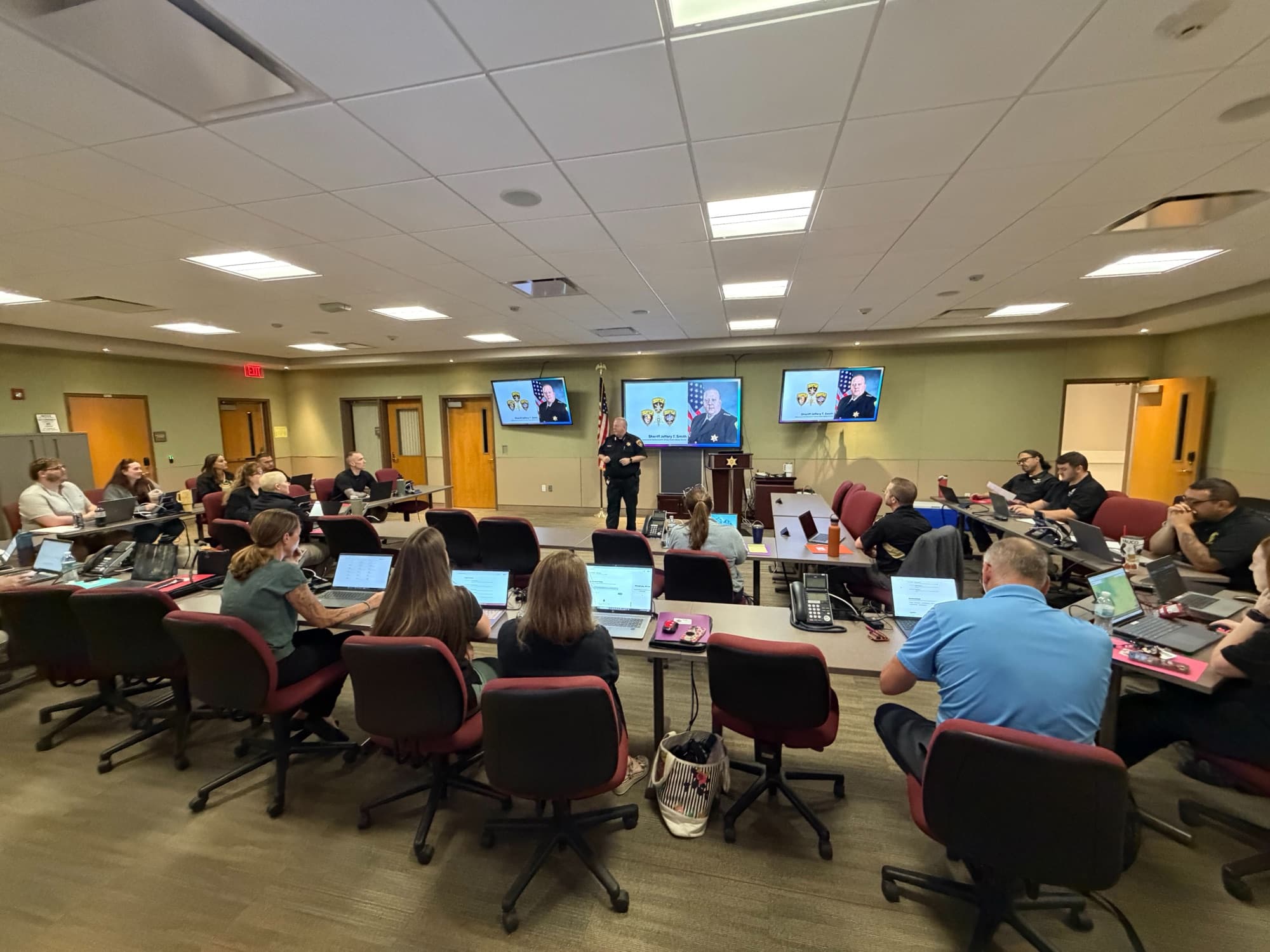 Montgomery County Sheriff Jeffery Smith addressing summit attendees working on laptops