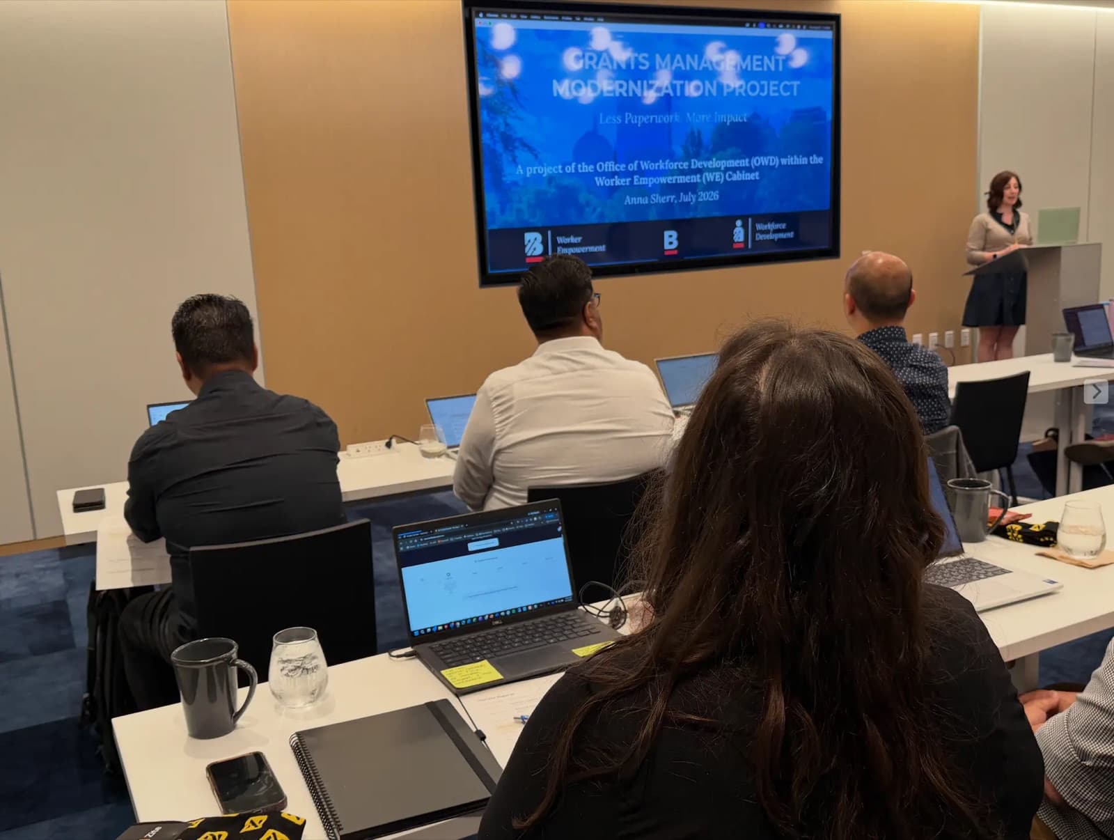 Anna Sherr presenting the City of Boston grants management project to attendees at laptops